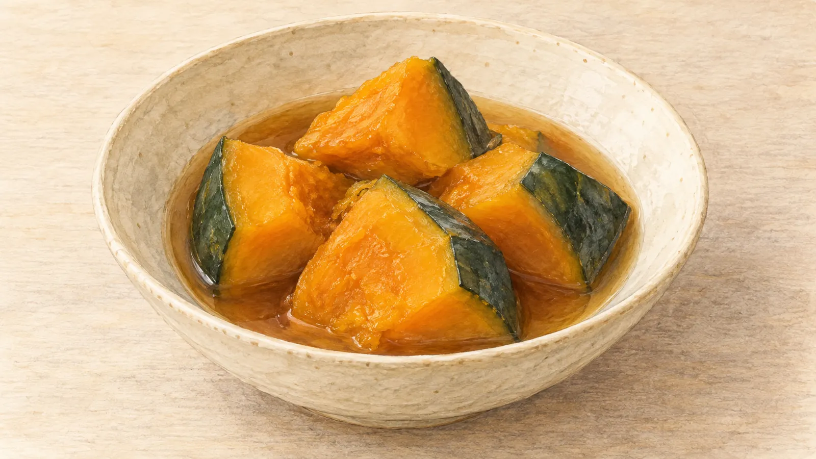 Watercolor illustration of orange kabocha chunks with dark green rind in a shallow bowl of light brown broth